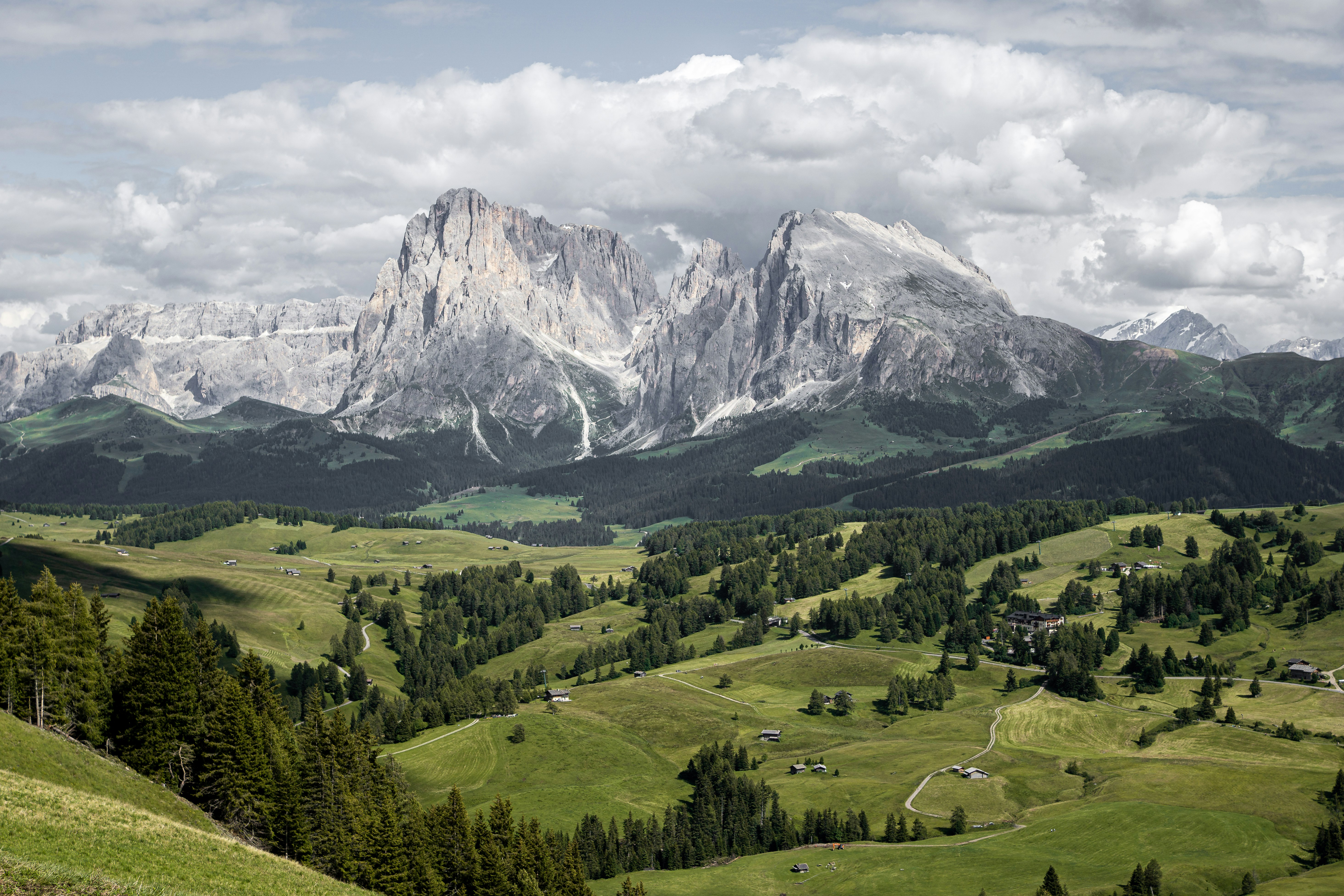 green grass field near snow covered mountain during daytime